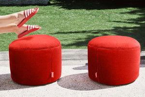 Two Red Fatboy Point Outdoor Ottomans with White Stitching on a Patio