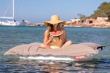 Load image into Gallery viewer, Model Floating on a Grey Taupe Fatboy Floatzac Eating a Watermelon