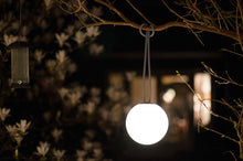 Load image into Gallery viewer, Taupe Fatboy Bolleke Lamp Hanging from a Tree Branch at Night