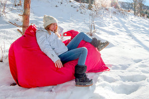 Model Sitting on a Red Fatboy Buggle-Up in the Snow
