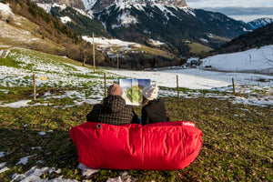 Couple Sitting on a Red Fatboy Buggle-Up in the Snow
