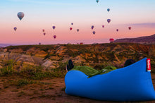 Load image into Gallery viewer, Person Laying on a Petrol Fatboy Lamzac the Original Watching Hot Air Balloons
