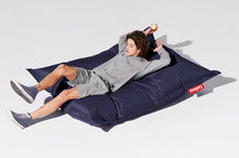 Load image into Gallery viewer, Guy Laying on a Blue Fatboy Original Slim Bean Bag Chair
