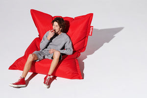 Guy Sitting on a Red Fatboy Original Bean Bag Eating an Apple