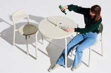 Load image into Gallery viewer, Model Sitting on a Fatboy Toni Chair at a Toni Bistreau Table
