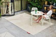 Load image into Gallery viewer, Model on a Patio Sitting on a Fatboy Toni Chair at a Toni Bistreau Table