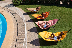 People Laying on Fatboy Headdemock Deluxe Hammocks by a Pool