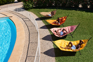 People Laying on Fatboy Headdemock Deluxe Hammocks by a Pool