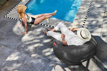 Load image into Gallery viewer, Guy Sitting on a Steel Grey Fatboy Lamzac O Inflatable Chair by the Pool
