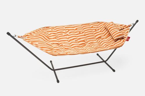 Orange zebra-patterned hammock on a black stand against a white background