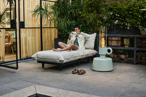 Guy Sitting on a Mist Fatboy Daybed Lounger on a Patio