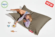 Load image into Gallery viewer, Person lying on a large brown bean bag with a visible brand logo, surrounded by small items on a white background.
