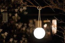 Load image into Gallery viewer, Sandy Beige Fatboy Bolleke Wireless Hanging Lamp Hanging on a Tree
