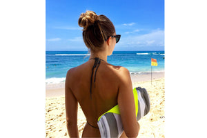 Girl Carrying a Folded Biarritz Fatboy Miasun Sun Shade on the Beach