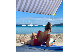 Girl Reading a Book Under a Biarritz Fatboy Miasun Sun Shade on the Beach 