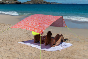 Two Girls Laying Under a Palm Beach Fatboy Miasun Sun Shade on the Beach