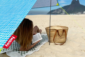 Girl Reading a Book Under a Venice Fatboy Miasun Sun Shade on the Beach