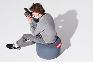 Guy Sitting on a Blue Fatboy Point Stonewashed Pouf with a Camera
