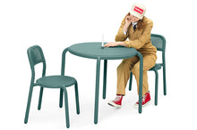 Load image into Gallery viewer, Model Sitting at a Pine Green Fatboy Toni Bistreau with Toni Chairs
