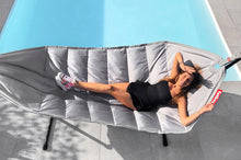 Load image into Gallery viewer, Model Laying on a Light Grey Fatboy Headdemock Deluxe Hammock by the Pool
