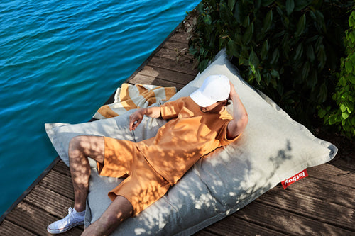 Guy Laying on a Mist Fatboy Bean Bag by the Water