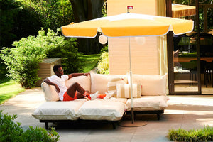 Model Sitting on a Paletti Lounge Under a Sunbeam Fatboy Sunshady Parasol