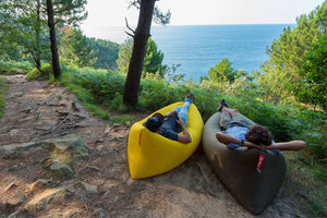 Two Guys Laying in Fatboy Lamzac the Originals on a Trail Near the Ocean