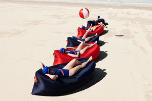 Models Laying in Red and Blue Fatboy Lamzacs on Beach