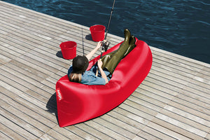 Girl Laying on a Red Fatboy Lamzac by the Water