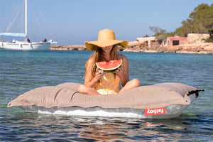 Model Floating on a Grey Taupe Fatboy Floatzac Eating a Watermelon