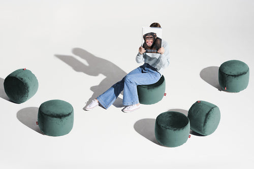Girl Sitting on a Petrol Fatboy Point Recycled Velvet Ottoman