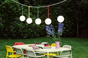 Fatboy Bolleke Lamps Hanging on a Rope Over a Toni Tablo Outdoor Dining Table