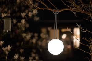 Taupe Fatboy Bolleke Lamp Hanging from a Tree Branch at Night