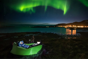 Guy Laying on a Grass Green Fatboy Lamzac the Original Under the Northern Lights