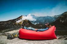 Load image into Gallery viewer, Hiker Laying on a Red Fatboy Lamzac the Original in the Mountains
