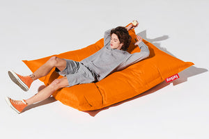 Guy Laying on an Orange Bitters Fatboy Original Slim Bean Bag Chair